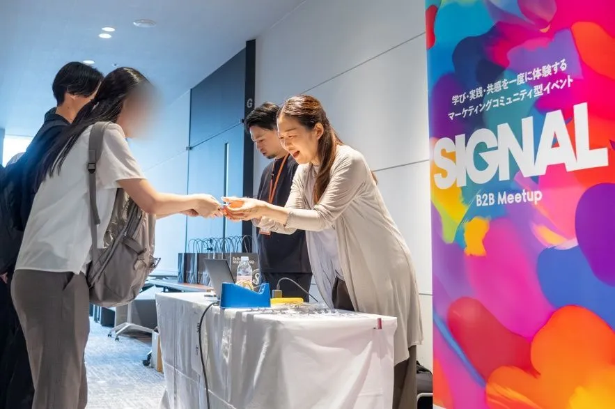 受付に立てられた SIGNAL B2B Meetup のバナー。開場とともに参加者が集まりはじめた